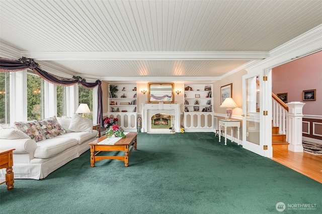 living area with stairway, built in features, ornamental molding, wainscoting, and a glass covered fireplace