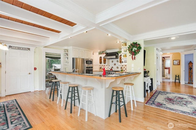 kitchen featuring open shelves, wall chimney range hood, and beamed ceiling