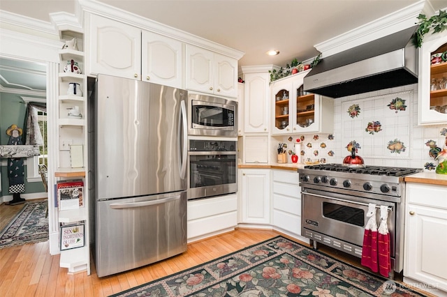 kitchen with white cabinetry, glass insert cabinets, light wood-type flooring, and appliances with stainless steel finishes