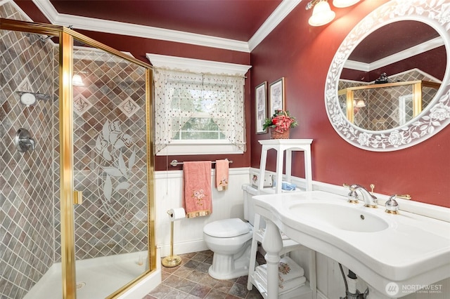 full bathroom with wainscoting, a stall shower, toilet, and crown molding