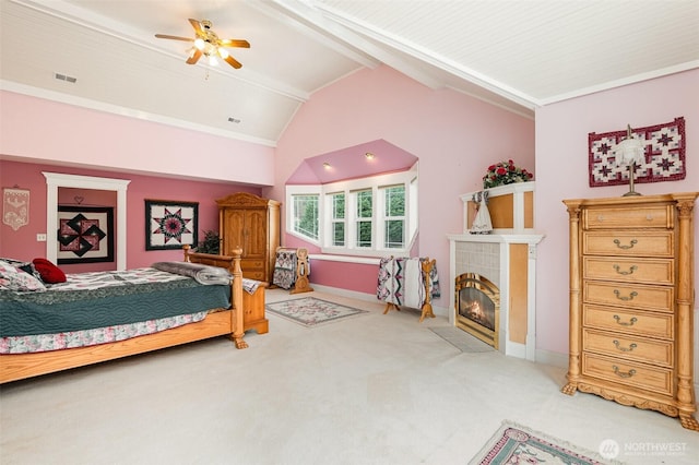 bedroom featuring carpet, visible vents, baseboards, lofted ceiling with beams, and a tiled fireplace