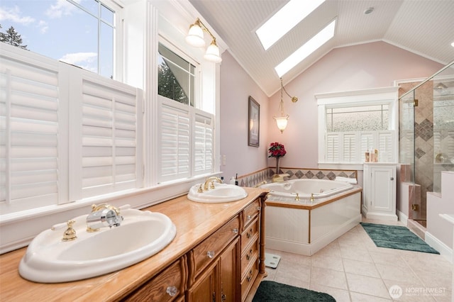 bathroom with tile patterned flooring, a tub with jets, a stall shower, and a sink