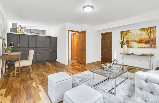 living area with baseboards and wood finished floors