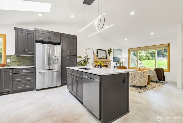 kitchen with tasteful backsplash, vaulted ceiling with skylight, stainless steel appliances, and light countertops