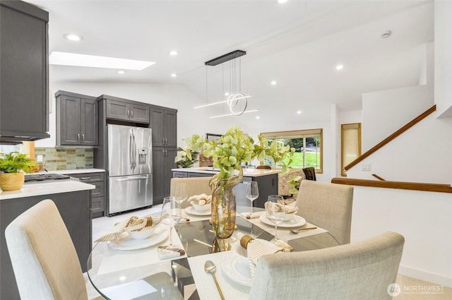 dining room with recessed lighting and vaulted ceiling with skylight