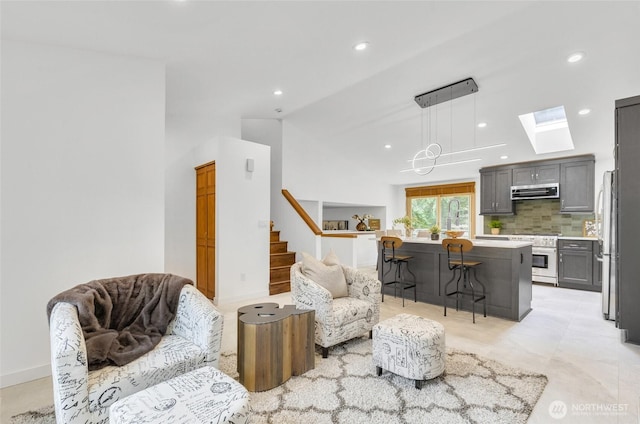 living area featuring recessed lighting, stairway, lofted ceiling with skylight, and baseboards