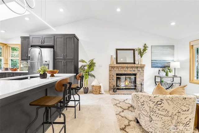 living area featuring lofted ceiling, recessed lighting, and a fireplace