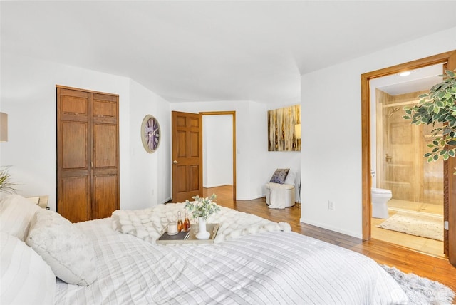 bedroom featuring connected bathroom, a closet, and wood finished floors