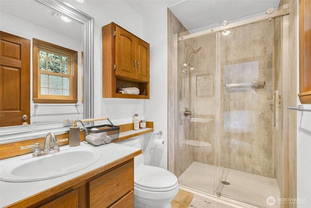 full bath featuring a stall shower, toilet, and vanity