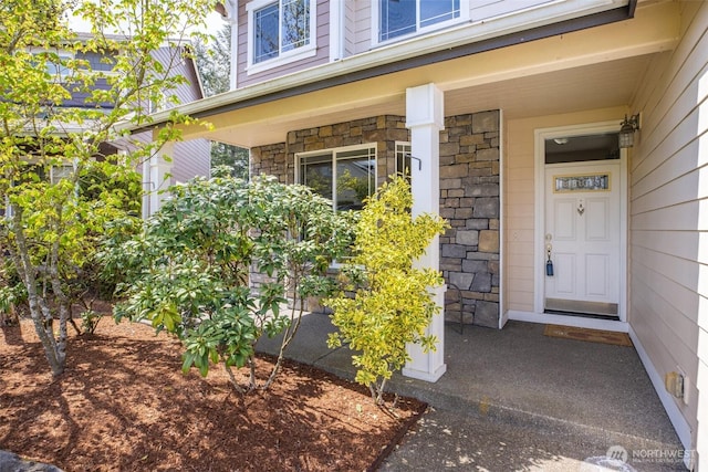 property entrance featuring stone siding and a porch