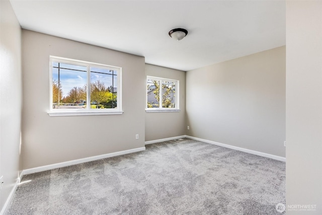 carpeted empty room with baseboards