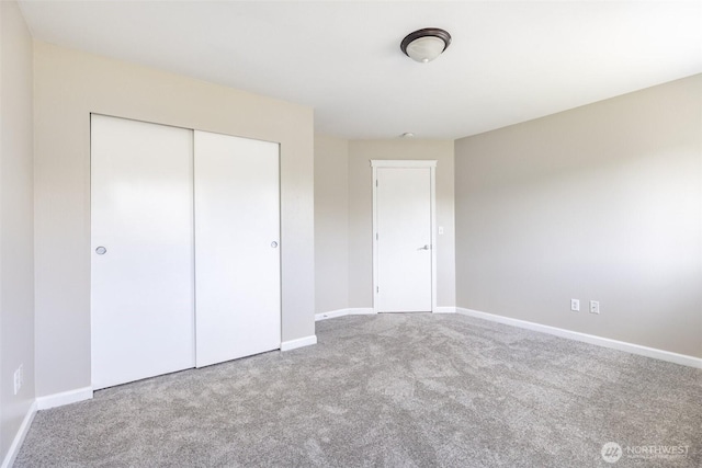 unfurnished bedroom with carpet, baseboards, and a closet