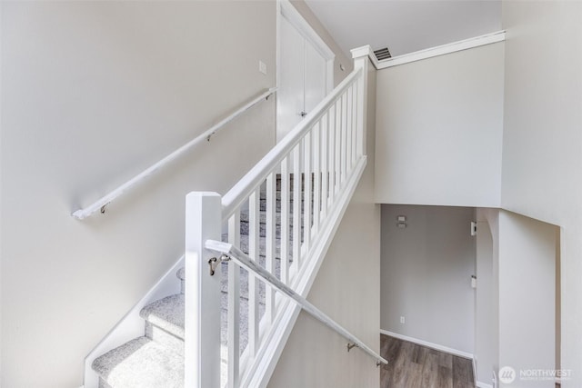 stairway featuring wood finished floors and baseboards