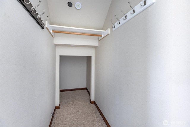 hallway featuring baseboards and carpet