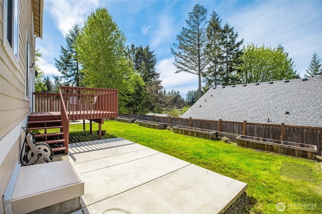 view of patio with a wooden deck, a vegetable garden, and fence