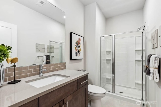 full bathroom with vanity, backsplash, a shower stall, and toilet