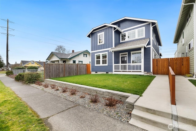 view of front of property featuring a front lawn, fence, covered porch, and board and batten siding