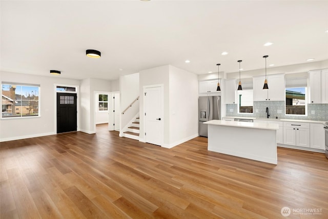 kitchen with decorative backsplash, light countertops, a center island, and stainless steel appliances