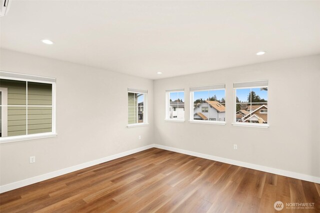 empty room featuring recessed lighting, baseboards, and wood finished floors