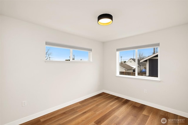 empty room with wood finished floors and baseboards