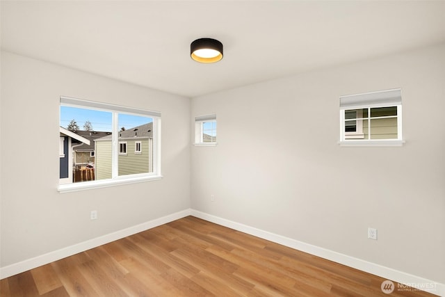 empty room featuring baseboards and light wood-style floors