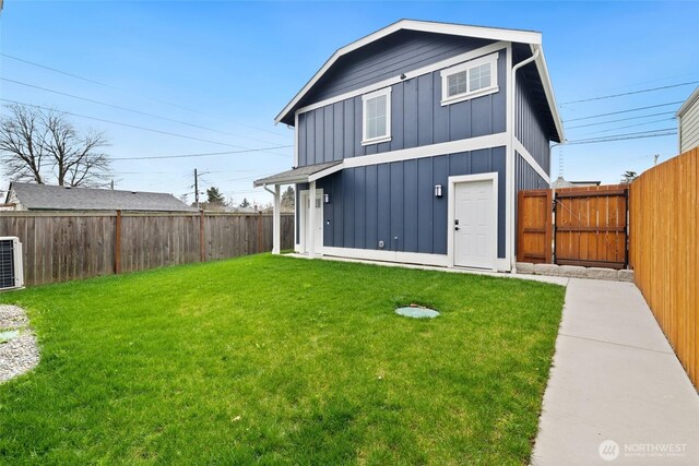 rear view of house featuring a fenced backyard, central AC unit, board and batten siding, and a yard