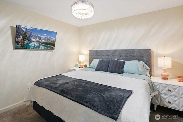 bedroom with baseboards, carpet, and a chandelier