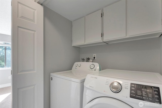 laundry area featuring cabinet space, independent washer and dryer, and baseboards