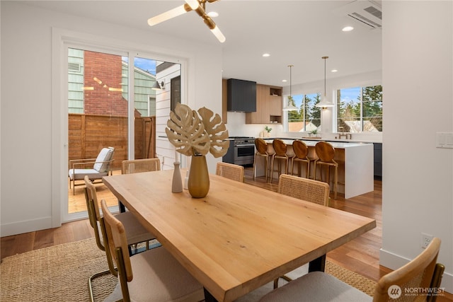 dining room with a ceiling fan, visible vents, baseboards, light wood-style flooring, and recessed lighting