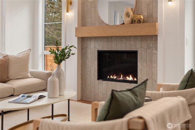 living area featuring a glass covered fireplace and wood finished floors