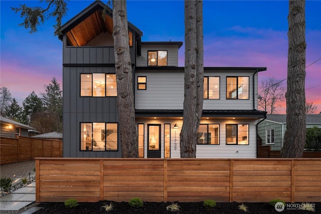 rear view of house with a fenced front yard and board and batten siding