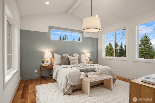 bedroom with recessed lighting, light wood-style floors, wainscoting, and vaulted ceiling with beams