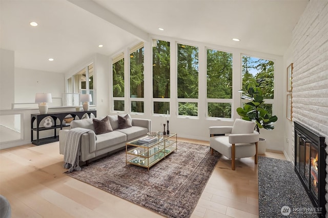 living area featuring recessed lighting, a large fireplace, a healthy amount of sunlight, and vaulted ceiling with beams