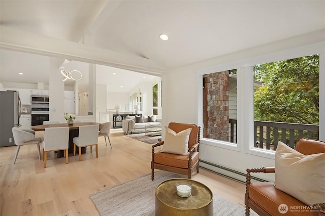 living room with recessed lighting, vaulted ceiling, light wood-style flooring, and a baseboard radiator