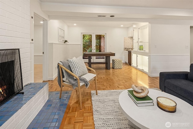 living room with visible vents, a fireplace, baseboards, and french doors