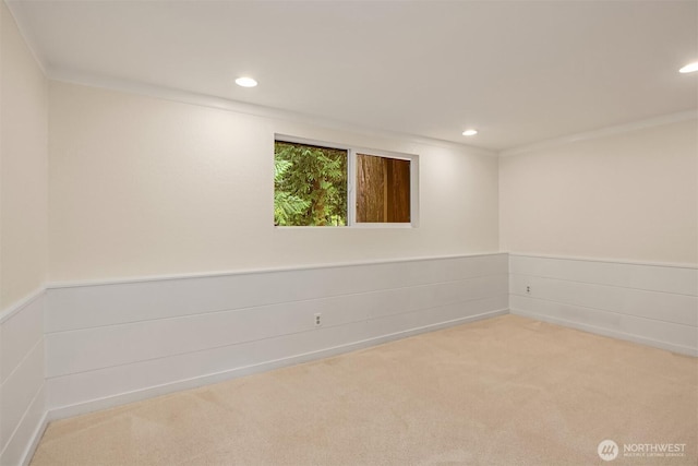 empty room featuring recessed lighting, a wainscoted wall, carpet floors, and ornamental molding