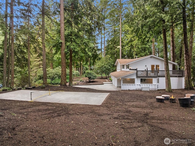 exterior space featuring a wooden deck and concrete driveway