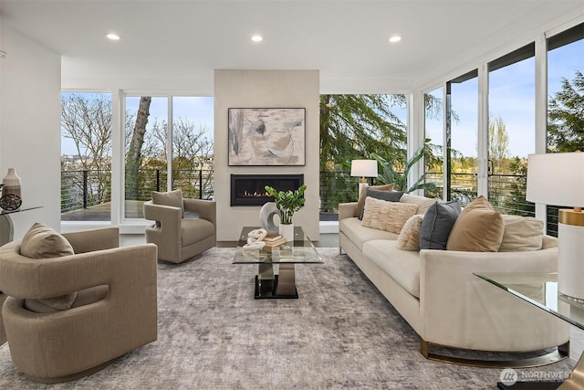 living room featuring recessed lighting and a warm lit fireplace