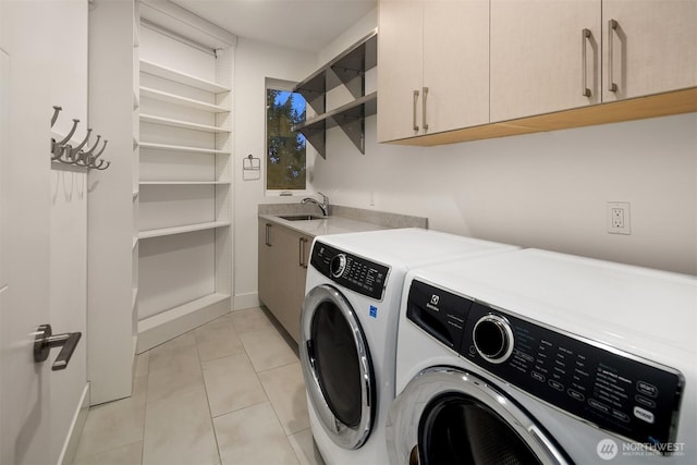 laundry area with cabinet space, light tile patterned floors, washer and dryer, and a sink