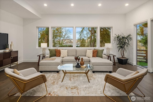 living area with recessed lighting, wood finished floors, and a healthy amount of sunlight