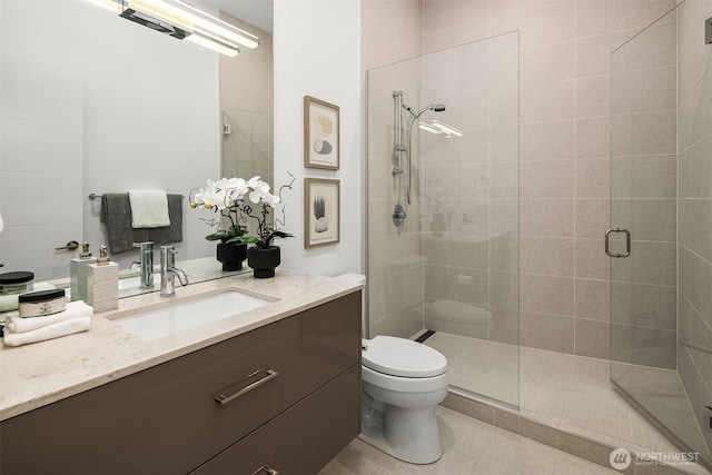 bathroom featuring vanity, tile patterned floors, toilet, and a stall shower