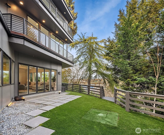 view of yard with a patio area, a balcony, and fence