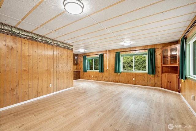 spare room featuring baseboards and wood finished floors