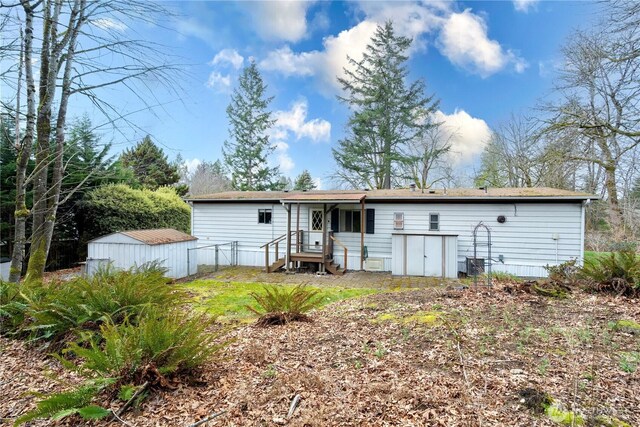 rear view of property with a storage shed and an outdoor structure