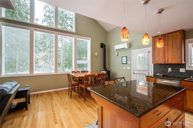 kitchen featuring a wood stove, light wood-style flooring, decorative backsplash, dishwasher, and brown cabinets