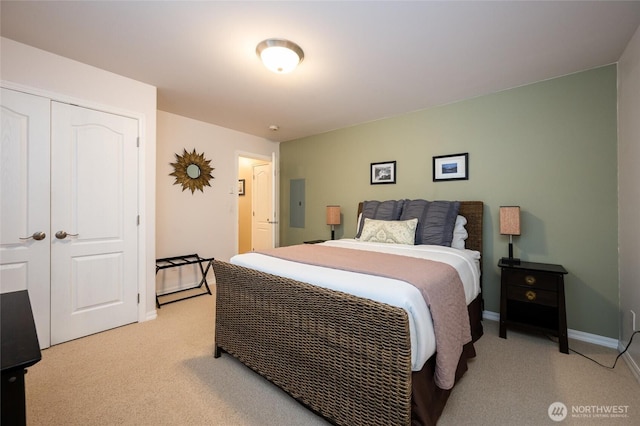 bedroom with electric panel, baseboards, a closet, and light carpet