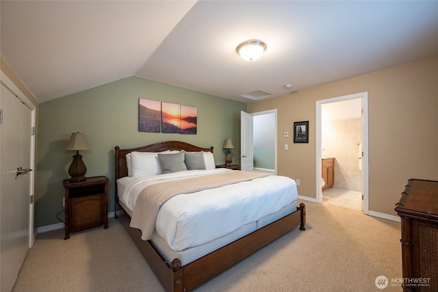 bedroom with baseboards, connected bathroom, light carpet, and lofted ceiling