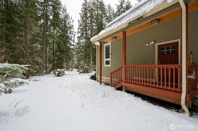 yard layered in snow featuring a porch