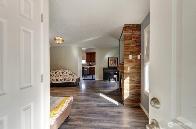 interior space featuring dark wood-type flooring, baseboards, and a textured ceiling