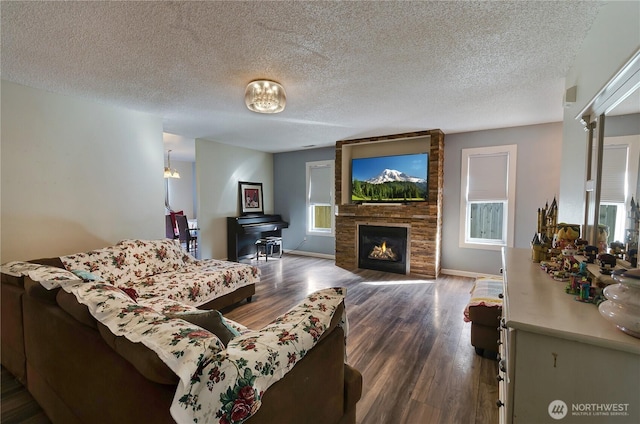 living room featuring dark wood finished floors, a fireplace, baseboards, and a textured ceiling